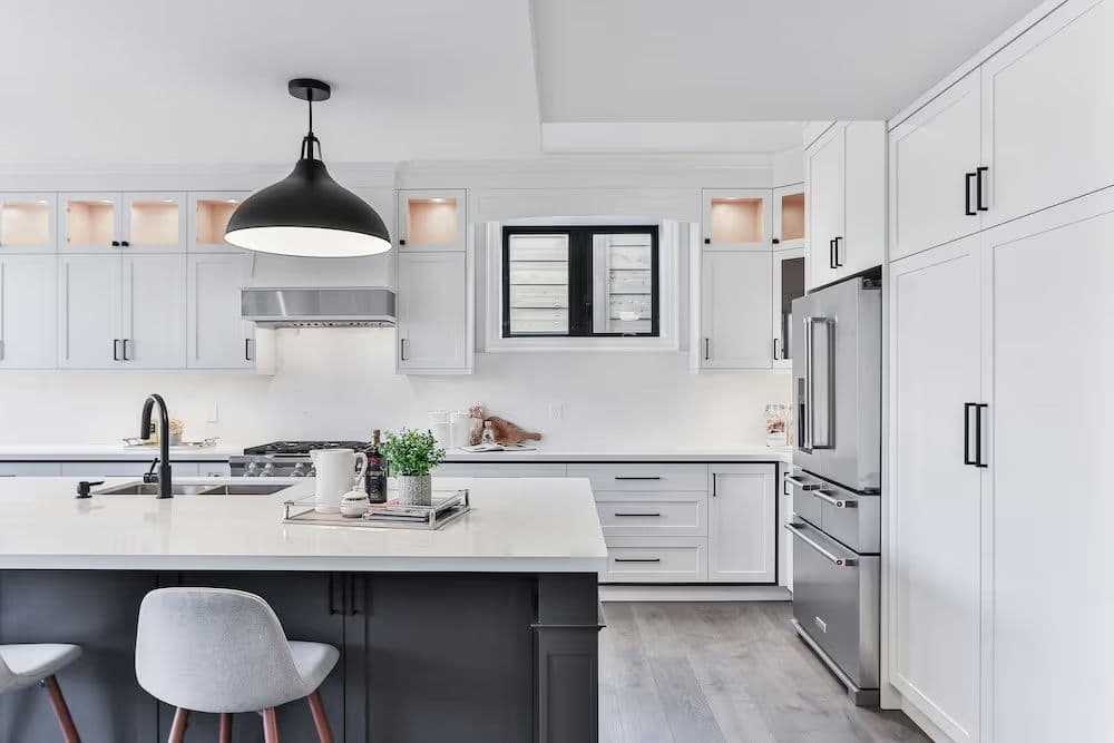 Modern kitchen featuring sleek white cabinetry, a stylish pendant light, and a spacious island.