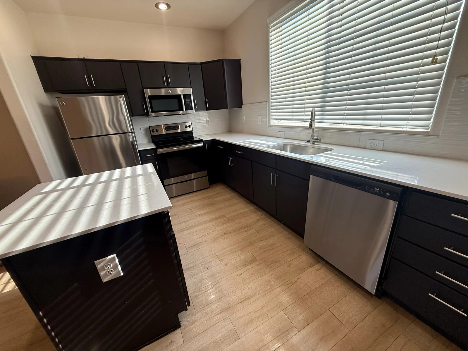 Clean kitchen with clear counters, an island and stainless appliances